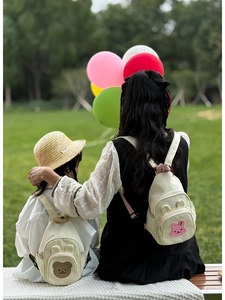 Photo de plein air montrant adulte et enfant avec des sacs de poitrine animaux mignons