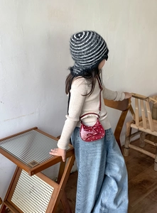 Toddler red polka dot crossbody bag with bows and ruffle handle shown on model