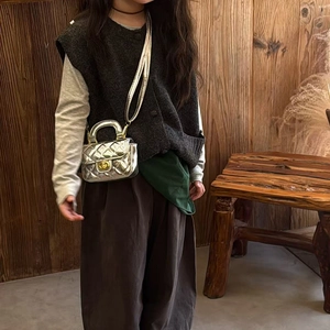 Girl's silver quilted crossbody bag with gold hardware and chain strap on child model