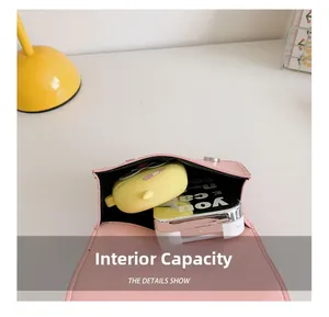 Détail de la capacité intérieure du sac matelassé rose avec maquillage et étui d'écouteurs