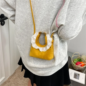 Mini sac à main jaune en daim avec dentelle blanche porté par un mannequin