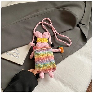 Detail of handmade crochet pink rabbit bag with rainbow texture and mini carrot charm