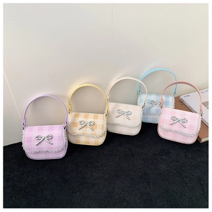 Detail of colorful gingham mini bags with white lace trim and metal bow accents