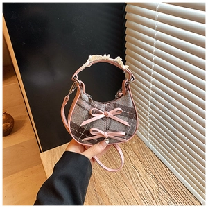 Dettaglio della borsa a scacchi per bambini con finiture in pelle rosa e manico in pizzo