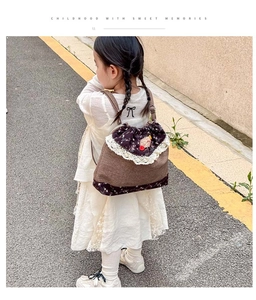 Detail of child drawstring backpack with lace trim and floral fabric stitching