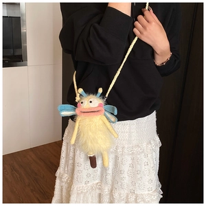 Détail du sac à bandoulière monstre jaune crocheté à la main porté par un mannequin