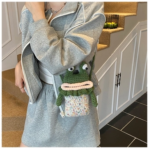 Détail du sac à bandoulière grenouille au crochet avec de grands yeux et une base colorée