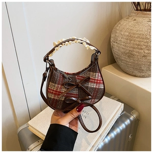 Dettaglio borsa vintage a quadri con fiocchi in pelle e manico in pizzo bianco