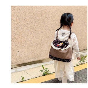 Detail of sweet forest style drawstring backpack with white lace and floral patchwork