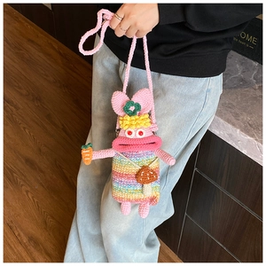 Detail of handmade crochet bunny crossbody bag with 3D carrot and mushroom decorations