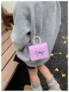 Détail du mini sac bandoulière matelassé violet avec poignée en perles et nœud argenté