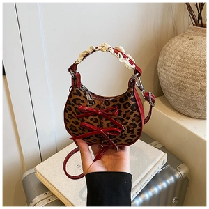 Dettaglio della borsa bimbi leopardata con fiocchi in lacca rossa e manico in pizzo