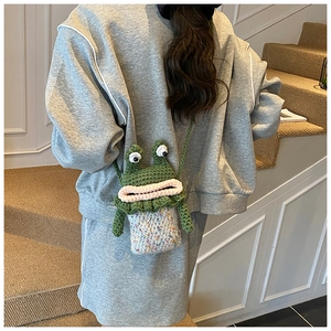 Détail d'un petit sac à bandoulière grenouille fait main au crochet avec de grands yeux