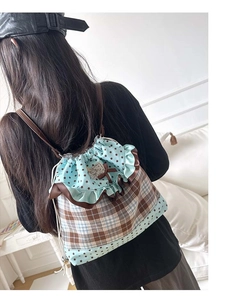 Detail of sweet drawstring backpack with ruffles, star patterns and cat patch