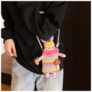 Detail of pink handmade crochet bag with funny bunny design and rainbow striped outfit