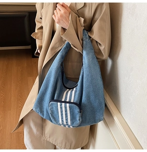 Detailed close-up of retro wash blue denim hobo tote bag with three white stripe accents