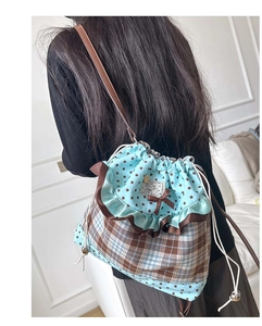 Detail of sweet drawstring bucket bag with brown plaid, blue dots and lace trim