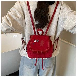 Détail d'un sac à dos éléphant rouge avec texture peluche et bretelles réglables
