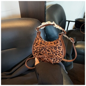 Dettaglio mini borsa leopardata con fiocchi marroni e pizzo bianco sul manico