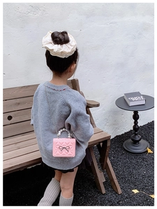 Mini sac enfant rose matelassé avec poignée perle et nœud en situation d'utilisation