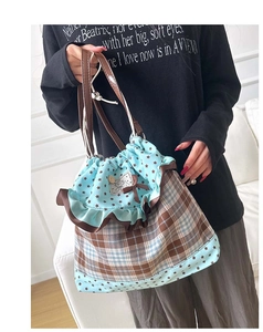 Detail of checkered canvas bag with star pattern, drawstring closure and cat patch