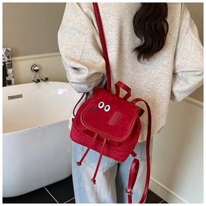 Vue arrière d'un enfant portant un sac à dos chien rouge mignon avec patchs yeux blancs