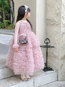 Detail of pink sequin vest and layered tulle cake skirt with matching bow crossbody bag