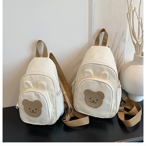 Détail de sacs de poitrine en toile crème pour enfants avec patchs d'ours en silicone