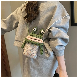 Détail d'un sac bandoulière grenouille tricoté main avec texture crochet pour enfant