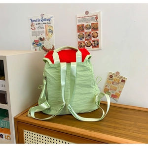 Pistachio green textured backpack featuring a contrasting red lining and adjustable straps