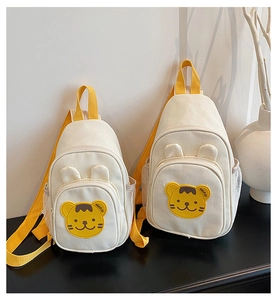 Vue détaillée du sac de poitrine en toile pour enfant avec broderie tigre et anses jaunes