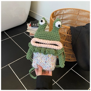 Détail d'un petit sac à bandoulière grenouille tricoté main avec de grands yeux rigolos