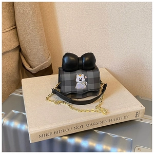 Détail du sac à bandoulière enfant à carreaux gris avec nœud noir et broderie