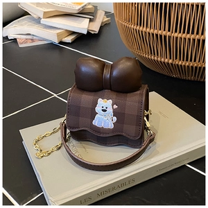 Détail du sac bandoulière à carreaux avec broderie chat et nœud en cuir marron