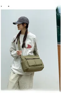 Detailed view of army green canvas tote with dual front pockets and adjustable strap