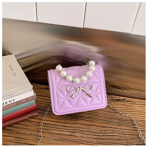 Détail du mini sac matelassé violet avec poignée en perles et nœud argenté