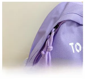 Close-up of purple canvas backpack with smooth metal zipper and thick braided pull cord