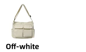 Detail of cream white canvas tote bag featuring double front flap pockets and adjustable straps