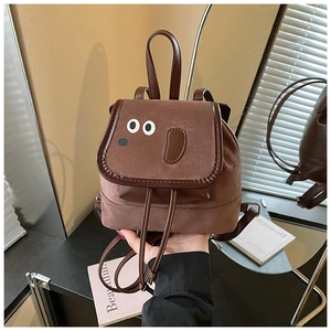 Détail du sac à dos chiot en daim marron avec finitions et poignées en cuir