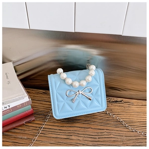 Détail du mini sac matelassé bleu clair avec anse en perles et fermoir nœud argenté