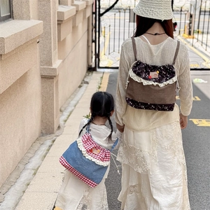 Sweet polka dot drawstring backpack with lace trim for mothers and kids in outdoor setting