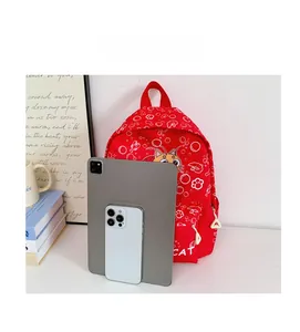 Size comparison of the red cartoon cat schoolbag with a tablet and smartphone