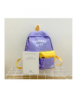 Detail of purple and yellow canvas backpack featuring letter print and zipped front pocket