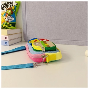 Detail of multi-color kids crossbody bag with metal zippers and layered pockets
