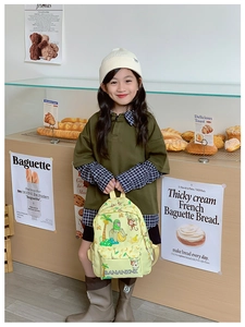 Close-up of yellow children's backpack featuring tropical monkey and banana prints