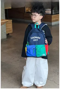 Detail of multi-pocket kids backpack with vibrant color-blocking and letter print