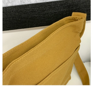 Close-up of mustard yellow canvas bag showing durable twill texture and reinforced stitching
