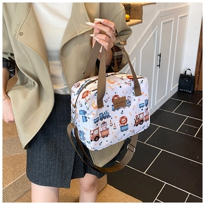 Lifestyle view of large cartoon print storage bag with brown strap and leather patch