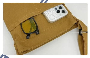 Detail of yellow canvas tote bag showing two front pockets for sunglasses and phone