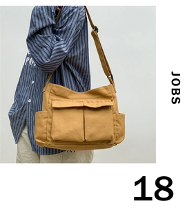 Detail of mustard yellow canvas tote bag featuring double front pockets and adjustable strap